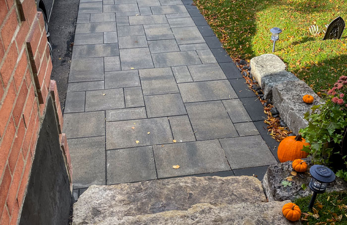 VanKuikConstruction-2024-entry-walkway-home2 Interlocking stone walkway leading up the a homes front door as part of the landscape design.